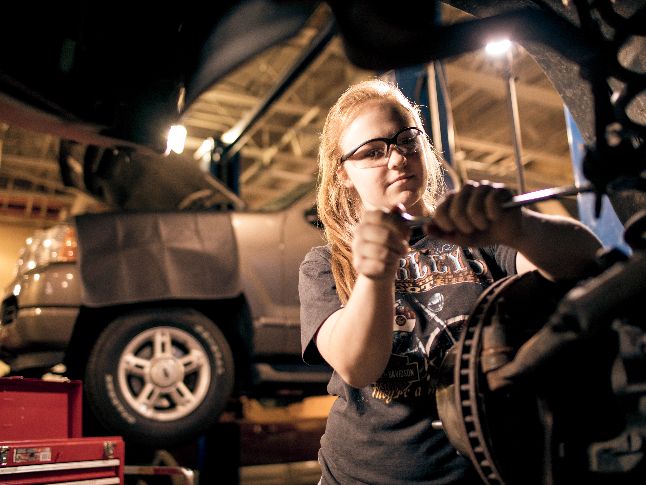  Student works on a car in automotive class.